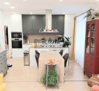 Küche in einer 3-Zimmer-Wohnung mit Holzboden, Esstisch und Bücherregal.