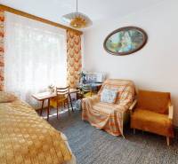 Ein Zimmer in einem Einfamilienhaus mit einem Bett, einem Teppich, einem Sessel und einem Bild an der Wand.