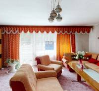 Wohnzimmer in einem Einfamilienhaus mit orangefarbenen Vorhängen und stilvoller Einrichtung.