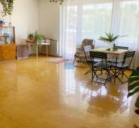 Ein geräumiges, helles Wohnzimmer, ein Boden mit Holzdekor, Möbel und Pflanzen in einem Einfamilienhaus.