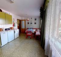 Eine Küche in einem Einfamilienhaus mit Retro-Möbeln, einem Tisch, einem großen Fenster und Dekorationen.