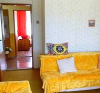 Wohnzimmer in einem Einfamilienhaus mit bunten Decken und Polsterungen auf den Sofas.