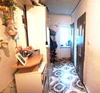 Flur mit Schränken und Dekorationen in einer Zweizimmerwohnung. Links Kleiderhaken, rechts Türen.