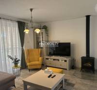 Wohnzimmer in einem Einfamilienhaus mit Kamin, gelbem Sessel und Fernseher.