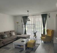 Wohnzimmer in einem Einfamilienhaus mit einem bequemen Sofa und einem gelben Sessel.