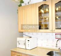 Küche in einer 3-Zimmer-Wohnung mit Schränken, Mikrowelle und Spüle.