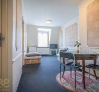 Ein Zimmer in Hotels und Pensionen mit einem runden Tisch und einem Fernseher auf einem Ständer.