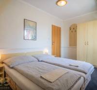 Doppelzimmer mit Bett, Nachttischen und Schrank in Hotels und Pensionen.