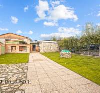 Der Garten beim Einfamilienhaus in der Kúpeľná-Straße in Dunajská Streda mit Rasen und Pflastersteinen.