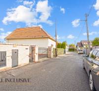 Ein Einfamilienhaus in der Kúpeľná-Straße in Dunajská Streda, umgeben von Autos und einem Zaun.