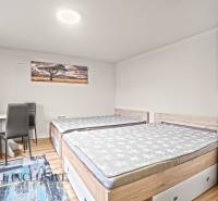 Ein Schlafzimmer in einem Einfamilienhaus mit zwei Betten, einem Schrank und einem Boden mit Holzdekor.