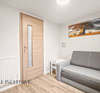 Wohnzimmer in einem Einfamilienhaus mit Sofa, Tisch und Holzboden.