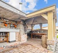 Exterieur eines Einfamilienhauses in der Kúpeľná-Straße in Dunajská Streda, Außenküche mit Sitzgelegenheit.