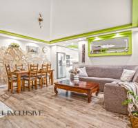 Wohnzimmer in einem Einfamilienhaus mit Steinwand und Boden in Holzoptik.