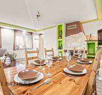 Esszimmer in einem Einfamilienhaus mit Holztisch, Gläsern und dekorativem Kamin.