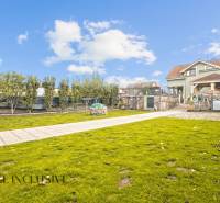 Der Garten des Einfamilienhauses in der Kúpeľná-Straße in Dunajská Streda mit gepflegtem Rasen und Bäumen.