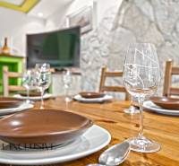 Ein gedeckter Esstisch in einem Einfamilienhaus mit einem Holzboden und einer Steinwand.