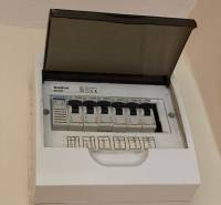 Elektrischer Verteilerkasten mit offenem Deckel und gekennzeichneten Sicherungsautomaten in einer Einzimmerwohnung.