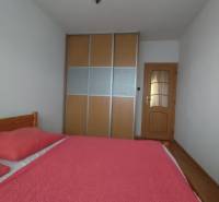 Schlafzimmer in einer 3-Zimmer-Wohnung mit Bett und Schrank mit Schiebetüren.