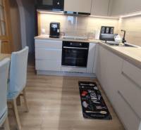 Küche mit Holzboden in einer 3-Zimmer-Wohnung, mit moderner Ausstattung und Dekor.