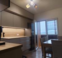 Küche mit Holzboden und Esstisch in einer 3-Zimmer-Wohnung.