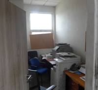 Kleines Büro mit Stühlen, Drucker und Fenster in Lagerhäusern und Hallen.