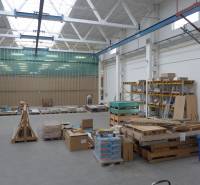 Im Lager befinden sich Paletten mit Baumaterial und Regale mit gelagerten Platten.