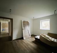 Ein Raum in einem Einfamilienhaus mit einem Holzboden und einfacher Einrichtung.