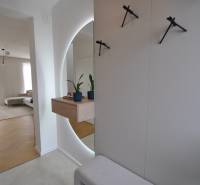 Innenraum eines Einfamilienhauses mit Holzboden, Spiegel und Zimmerpflanzen.