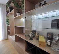 Innenraum eines Einfamilienhauses mit einem Schrank, Glasregalen und einem Boden mit Holzdekor.