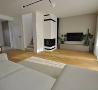 Wohnzimmer in einem Einfamilienhaus mit Kamin und Boden in Holzoptik.