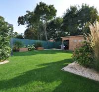 Der Garten des Einfamilienhauses in der Ďuríčkova-Straße in Miloslavov mit einem Holzunterstand und Grünflächen.