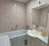 Badezimmer mit Badewanne, Waschbecken und Spiegel in einer 3-Zimmer-Wohnung.