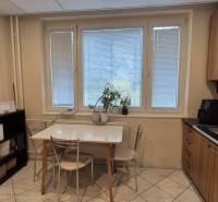 Küche einer 3-Zimmer-Wohnung mit Esstisch, Küchenzeile und Mikrowelle.