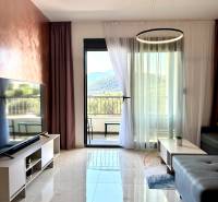 Wohnzimmer in einer Einzimmerwohnung mit Marmorboden und Blick auf die Berge.