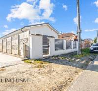 Ein Einfamilienhaus in Orechová Potôň mit einer Steinmauer und einem geparkten Auto auf der Straße.