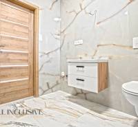 Badezimmer in einem Einfamilienhaus mit Fliesen und Bodenbelag in Marmoroptik.