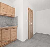 Küchenzeile mit Holzdekor und grauen Fliesen in einem Einfamilienhaus, Fliesenboden.