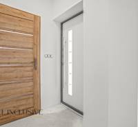 Innenraum eines Einfamilienhauses mit Holzelementen und einfachen weißen Wänden.