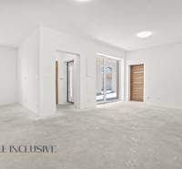 Geräumiges Interieur eines Einfamilienhauses mit weißen Wänden und Fliesenboden.