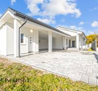 Ein Einfamilienhaus in Orechová Potôň mit weißer Fassade und gepflastertem Eingang.