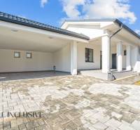 Einfamilienhaus in Orechová Potôň mit Terrasse und Carport auf Pflastersteinen.
