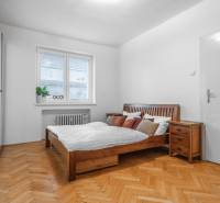Schlafzimmer in einer 3-Zimmer-Wohnung mit Holzmöbeln und einem Boden mit Holzdekor.