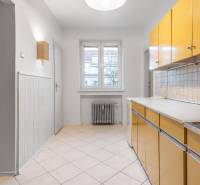 Küche in einer 3-Zimmer-Wohnung mit farbiger Küchenzeile, Heizkörper und Fliesenboden.