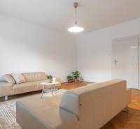 Wohnzimmer in einer 3-Zimmer-Wohnung mit Sofas und Holzboden.