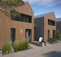 Ein Einfamilienhaus in Turecká mit Holzverkleidung, Menschen entspannen auf einer Bank.