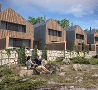 Einfamilienhäuser in Turecká mit Holzverkleidung, umgeben von Natur und Steinmauern.