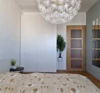 Schlafzimmer mit dekorativer Leuchte, Kleiderschrank und Holzboden in einer 3-Zimmer-Wohnung.