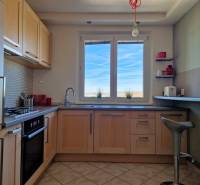 Küche mit Fenster, Boden mit Holzdekor, Fliesen, Einrichtung in einer 3-Zimmer-Wohnung.