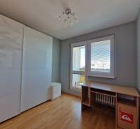 Ein Zimmer in einer 3-Zimmer-Wohnung mit einem Boden in Holzoptik, einem Tisch und einem Schrank.